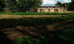 De resten van een van de bijgebouwen in het park bij het landhuis