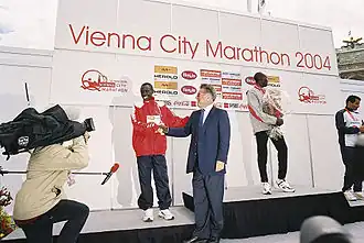 Kipkoech wordt gefeliciteerd met zijn tweede plaats in de marathon van Wenen in 2004 door de president van Oostenrijk.