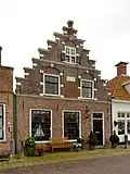 Pand met boven de puibalk een versierde trapgevel