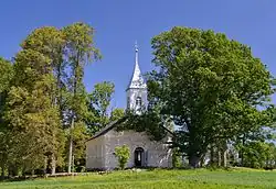Vooraanzicht van de kerk met rechts de heilige eik