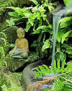 Beeldje bij waterval in de varenhof