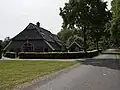 Boerderij; aan voor- en achterzijde afgewolfd rieten zadeldak. Woonhuisgedeelte gewijzigd. Bakhuisje