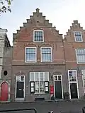 Huis met trapgevel, bekroond door overhoekse pinakeltje