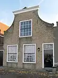 Huis met klokgevel, bekroond door lijst