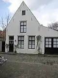 Huis met gepleisterde topgevel aan de straat