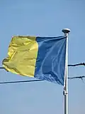 Wapperende vlag met de kleuren van de gemeente Opwijk