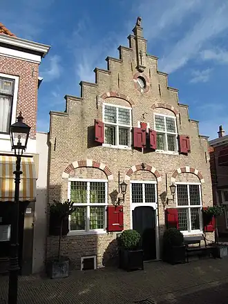 Vossenburch. Pand met trapgevel met maskerkoppen als sluitstenen boven de vensters