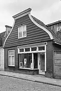 Winkel-woonhuis, pand met afgeknotte houten lijstgevel