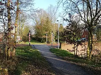 Voormalige spoorwegovergang bij Nijtap-Folgeren, in 2008 in de bestrating van de weg aangegeven. Naast de kruising staan vier speciaal ontworpen spoorweglampen.