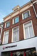 Pand met volledige en halve verdieping en door rechte kroonlijst met sierlijke rococo consoles gesloten gevel