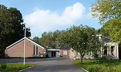 Nederlandse gereformeerde kerk (deels uit 1974) met rechts de pastorie