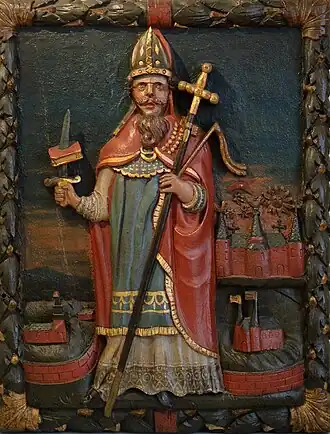 18e-eeuws houten reliëf met Bonifatius, met kruis en zijn attribuut (doorstoken evangelieboek) en drie steden: Dokkum (linksonder), Fulda en Mainz (?)