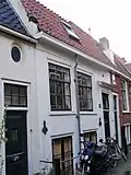 Laag huis met bogen boven benedenvensters, souterrain gepleisterd