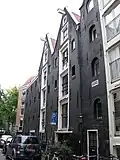 Pakhuiscomplex op scherpe hoek Koggestraat/Teerketelsteeg bestaande uit: a) een dubbel pakhuis met voorgevel eindigend in twee gewijzigde punttoppen en aan de achterzijde twee puntgevels