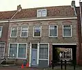 Huis met brede gecementeerde rechte gevel