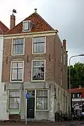 Huis met eenvoudige lijstgevel, benedenstuk gepleisterd