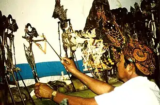 Een Surinaams-Javaanse dalang (poppenspeler) speelt wayang kulit