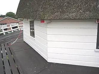 Met rabatdelen bedekte houten achtkant