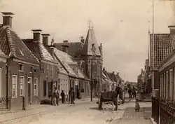 De Waterstraat in Delfzijl rond 1900 met op de achtergrond de Waterpoort. Afgezien van de poort is vrijwel alle bebouwing sindsdien gesloopt om plaats te maken voor nieuwe gebouwen.