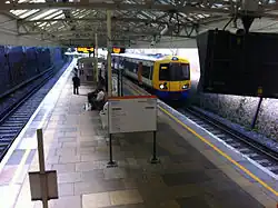 Een treinstel van de overground rijdt binnen op Watford High Street