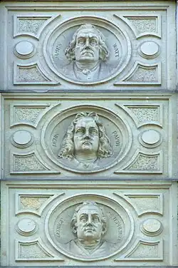 Medaillons in de voorgevel met James Watt, Denis Papin en George Stephenson uitgebeeld.