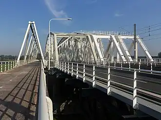 De bruggen, met links de fietsbrug, daarnaast de verkeersbrug en rechts de twee spoorbruggen