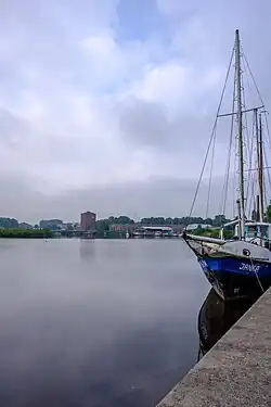 Gezicht op de bebouwing van Oudezijl (met locomotiefloods) over de Westerwoldse Aa vanuit het noordoosten