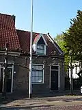 Huis onder zadeldak met langsgevel aan de straat. Schuiframen met negen ruiten. Kap 19e-20e eeuw gewijzigd