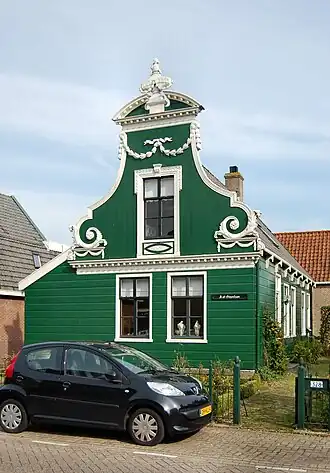 Houten huis met rijk versierd voorschot in Lodewijk XVI-stijl