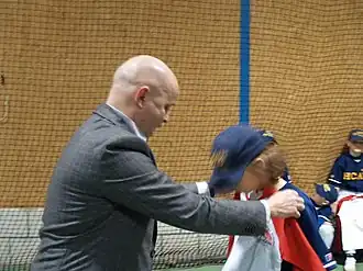 Gerard Boekhoff deelt T-shirts uit aan jongeren die de honkbalschool van HCAW te Bussum hebben doorlopen