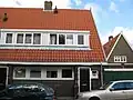 Blok met 4 keukenwoningen, zo genoemd vanwege destijds nieuwe plaatsing van keuken aan de voorzijde, aan de zijkant een houten topgevel, bouwstijl Amsterdamse School, aansluitend op andere keukenwoningen in Tuindorp Nieuwendam
