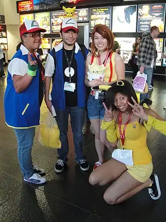 Pokémon cosplayers, het meisje heeft een knuffel van Togepi vast