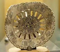 Shell gorget met in het midden een spinmotief en eromheen een rij handen met armbanden - Woolaroc Museum