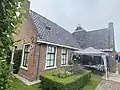 Boerderij met gestrekt woonhuis met gepleisterde top en dwarsbouw met topgevel