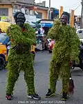 Jongens in kostuums gemaakt van grassen, X'Mas in Tadi, Ghana, 26 december 2020