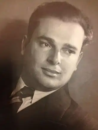 Een portretfoto van Isaac Levy. Hij is op deze foto gekleed in een donker pak met een stropdas.