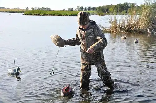 Jongen met houten lokeend voor de eendenjacht