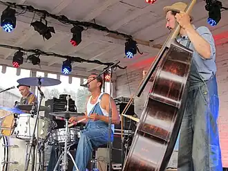 T-99 treedt op op een veranda op de Zwarte Cross, met een gitaar, drumstel en een contrabas