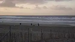 De uitstroomgeul en een zandbank met brekende golven. Daarachter een diepte en een tweede zandbank.