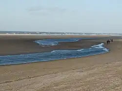 De oorspronkelijk rechte oude geul loopt sinds 2013 in een bocht. Bij eb splitst hij in twee delen. Op de voorgrond de afwatering naar de lagune.