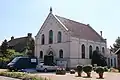 Gereformeerde kerk gebouwd in baksteen in kruisverband met een zadeldak dat haaks op de weg staat. Rond de kerk is het erf bedekt met grind.