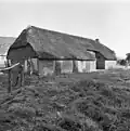 Boerderij onder rieten wolfsdak met zijbaander in de linkerzijgevel
