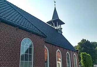 Zijaanzicht van de kerk, met klokkentoren