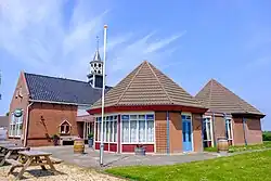 Voormalige lagere school uit 1868, in 1956 verbouwd tot dorpshuis 'Fivelhoes' en vervolgens nog sterk uitgebreid