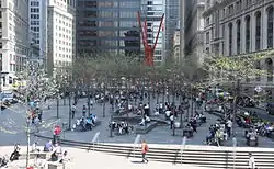 Zuccotti Park, voorjaar 2015. Het kunstwerk van Mark di Suvero is zichtbaar in de verte