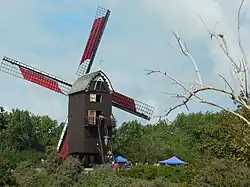 De Zuid-Abdijmolen met wieken met zeilen en bezoekers