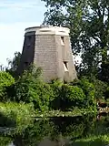 Westbroekmolen/Zuidbuurtse Molen. met riet gedekte molenromp op stenen onderbouw