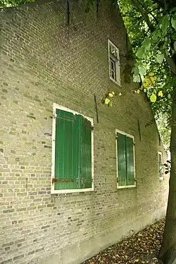 Hoeve met puntgevel. Vensters met oude kozijnen en luiken. Stal van gepotdekselde houten delen